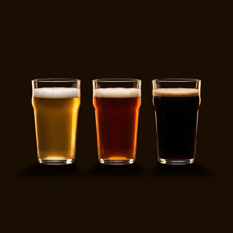 Trois verres de bière alignés, blonde, ambrée et brune
